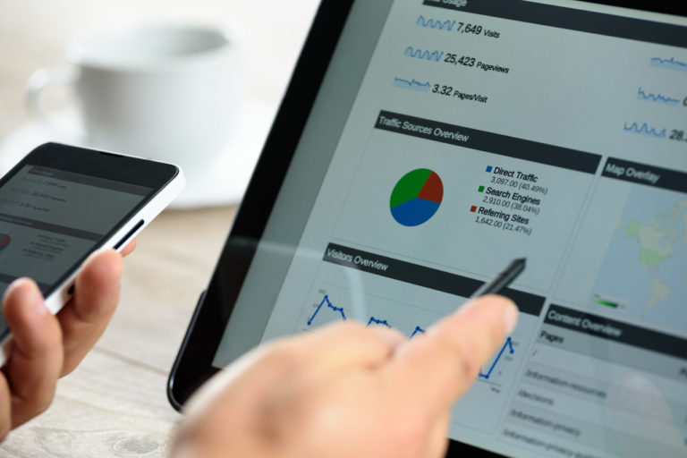 a hand pointing to a pie chart on a tablet